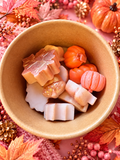 Egyptian Amber Autumn Scoopies waxident assortment in a kraft tub, with pumpkin and leaf shapes on a pink autumn background.