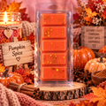 Orange Pumpkin Spice wax melt bar with gold flecks, displayed beside pumpkins and cinnamon sticks.