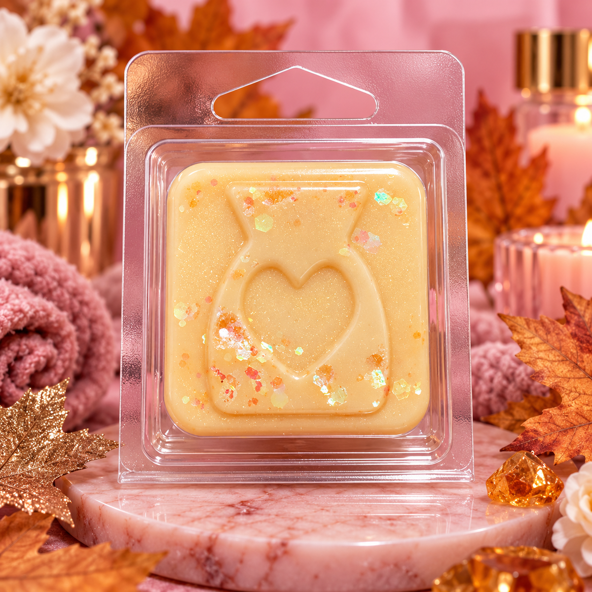 Cream White Musk & Golden Maple sample wax melt with a heart design and decorative flecks on a pink autumn background.